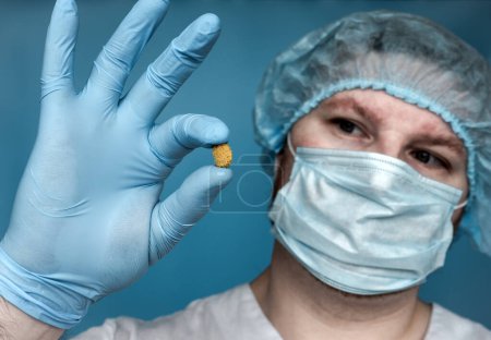 Removed Stone 14 mm from the kidney, in the doctor's hands. Human urolithiasis. Phosphate or oxalate kidney stone. Urologist surgeon demonstrates a kidney stone. Doctor in medical uniform.