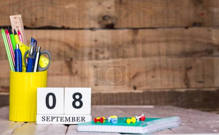 Téléchargez les photos : Septembre fond du calendrier avec le numéro 8. Stylos et crayons de papeterie dans une boîte sur un fond vintage en bois. Bloc-notes d'espace de copie avec crayons et calendrier. Place du planificateur pour le texte. - en image libre de droit