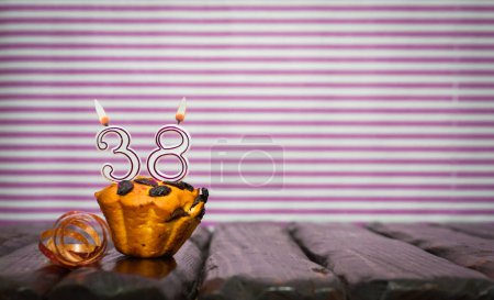 Foto de Cumpleaños número 38. Fecha de nacimiento con número de velas, espacio para copiar. Fondo de aniversario con pastel o magdalena con velas encendidas. Tarjeta de felicitación. - Imagen libre de derechos