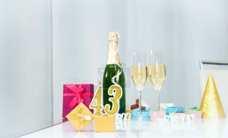 Téléchargez les photos : Date de naissance avec le numéro 43. Champagne festif dans des verres avec coffrets cadeaux, carte postale anniversaire. Joyeux anniversaire bougies dorées. - en image libre de droit