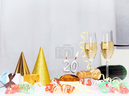 Foto de Fecha de nacimiento 20. Fondo festivo con una botella de champán. Champán festivo en copas con cajas de regalo, tarjeta de aniversario, decoraciones de feliz cumpleaños en colores blancos - Imagen libre de derechos