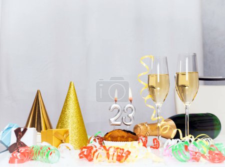 Foto de Fecha de nacimiento 23. Fondo festivo con una botella de champán. Champán festivo en copas con cajas de regalo, tarjeta de aniversario, decoraciones de feliz cumpleaños en colores blancos - Imagen libre de derechos