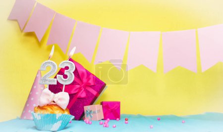 Date of birth with cake and number  23. Colorful card happy birthday for a girl. Copy space. Anniversary card pink. Congratulations on the decorations are beautiful.
