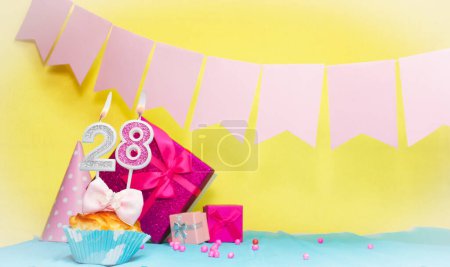 Date of birth with cake and number  28. Colorful card happy birthday for a girl. Copy space. Anniversary card pink. Congratulations on the decorations are beautiful.