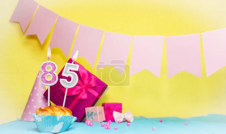 Date of birth with cake and number  85. Colorful card happy birthday for a girl. Copy space. Anniversary card pink. Congratulations on the decorations are beautiful.