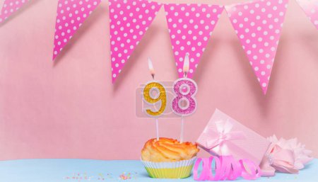 Date of Birth  98. Greeting card in pink shades. Anniversary candle numbers. Happy birthday girl, polka dot garland decoration. Copy space.