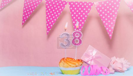 Fecha de nacimiento 38. Tarjeta de felicitación en tonos rosados. Números de velas de aniversario. Chica feliz cumpleaños, decoración de guirnalda de lunares. Copiar espacio.