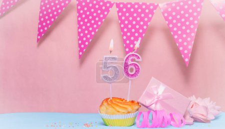 Geburtsdatum 56. Grußkarte in rosa Farbtönen. Jubiläums-Kerzen-Zahlen. Herzlichen Glückwunsch zum Geburtstag, Tupfen Girlanden Dekoration. Kopierraum.