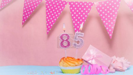 Date of Birth  85. Greeting card in pink shades. Anniversary candle numbers. Happy birthday girl, polka dot garland decoration. Copy space.