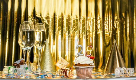 Date de naissance avec le numéro 28. Décors verres de champagne festifs, anniversaire de couleur dorée. Espace de copie. Joyeux anniversaire carte postale.