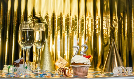 Background date of birth with number 72. Scenery festive glasses of champagne, anniversary in golden color. Copy space. Happy birthday postcard.