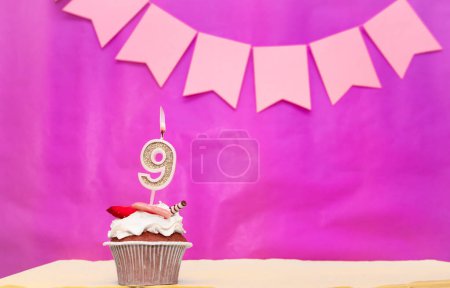 Téléchargez les photos : Contexte date de naissance avec le numéro 9. Fond rose avec un gâteau et des bougies allumées, économiser de l'espace, joyeux anniversaire pour une fille. Muffin au pudding de vacances. - en image libre de droit