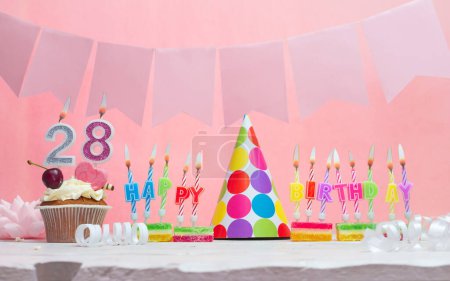 Background date of birth number  28. Anniversary. Beautiful festive background with candles for a girl. Women's congratulations postcard. Happy birthday in pink.
