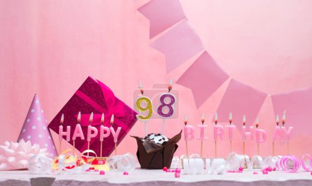Background card date of birth for a girl  98. Anniversary. Beautiful festive background with candles. Women's congratulations card with a cake. Happy birthday in pink. copy space