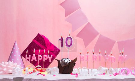 Background card date of birth for a girl  10. Anniversary. Beautiful festive background with candles. Women's congratulations card with a cake. Happy birthday in pink. copy space