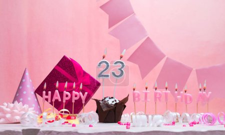 Background card date of birth for a girl  23. Anniversary. Beautiful festive background with candles. Women's congratulations card with a cake. Happy birthday in pink. copy space