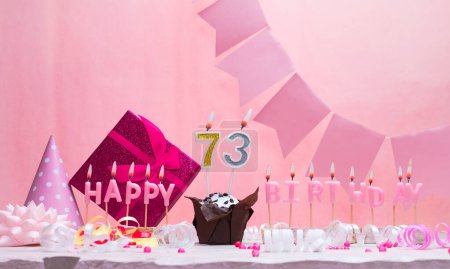 Background card date of birth for a girl  73. Anniversary. Beautiful festive background with candles. Women's congratulations card with a cake. Happy birthday in pink. copy space