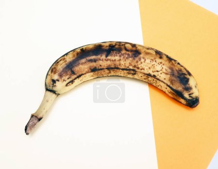 Bananas on a bright yellow background, banana fruit with black peel on a colorful background