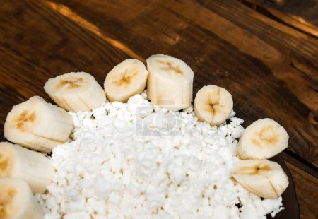 Appetizing sliced banana with cottage cheese in a plate, Slices with cheese dairy product.