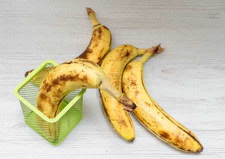 Banana in a stationery case. Banana on the desktop in the office. Ripe banana on a wooden table in a basket.