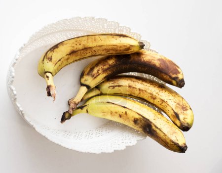 Bananes mûres dans un panier blanc dans la cuisine.
