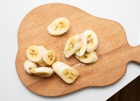 A man holds a sliced banana in his hands. Keep bananas in pieces without peel.