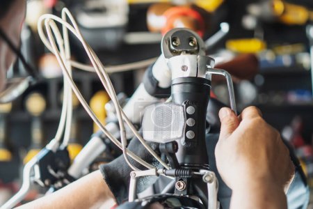 Photo for Technician makes adjustments to handlebar Stem on a folding bicycle working in workshop , Bicycle Repair and maintenance concept - Royalty Free Image