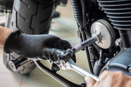 Photo for Mechanic use oil filter wrench removal tool on motorcycle at garage ,concept of motorcycle maintenance and repair. selective focu - Royalty Free Image