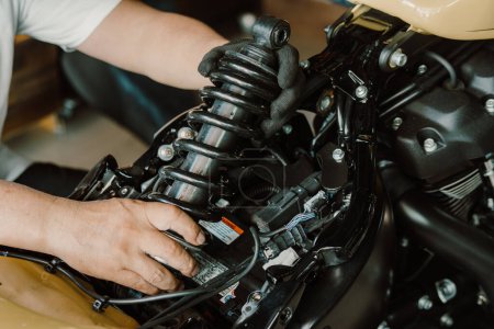 Motorradmechaniker-Check und Änderung Stoßdämpfer Motorrad in Motorradwerkstatt, Reparatur-, Wartungs- und Servicekonzept     