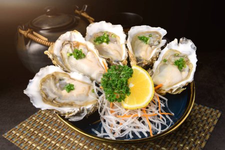 Photo for Fresh opened oysters in a plate with lemon on japanese style textured background - Royalty Free Image