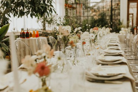 Modern stylish wedding table setting. The wedding decor. The pastel colors flowers bouquet. Natural beautiful wedding decorations. Minimalistic wedding decorations