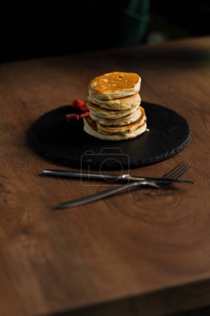 Téléchargez les photos : Gros plan d'une pile de crêpes avec des fraises sur la table pour le petit déjeuner - en image libre de droit