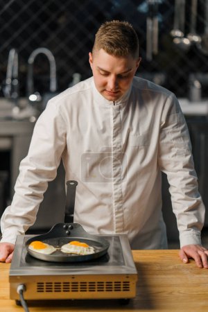 Foto de Chef freír huevos en pan cocina profesional Restaurante de desayuno - Imagen libre de derechos
