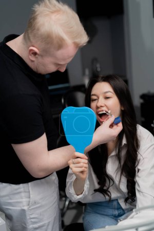 Téléchargez les photos : Médecin de la dentisterie consultation sur le blanchiment des dents sélection des couleurs - en image libre de droit