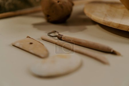 Photo for A potter works a clay vase with potter's knife in pottery workshop - Royalty Free Image