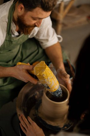 Photo for A potter dries finished clay jug in pottery workshop - Royalty Free Image
