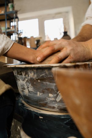 Foto de Taller de cerámica alfarero trabaja con el producto de la rueda del alfarero hecho de alfarero de arcilla conduce clase magistral - Imagen libre de derechos