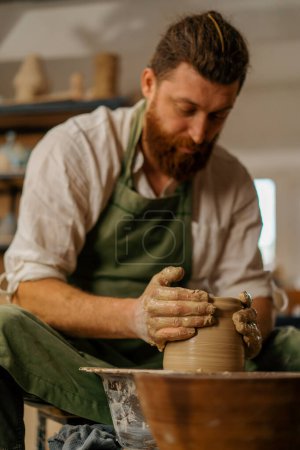 Foto de Taller de cerámica Un alfarero trabaja con arcilla en herramientas de cerámica de rueda de alfarero - Imagen libre de derechos
