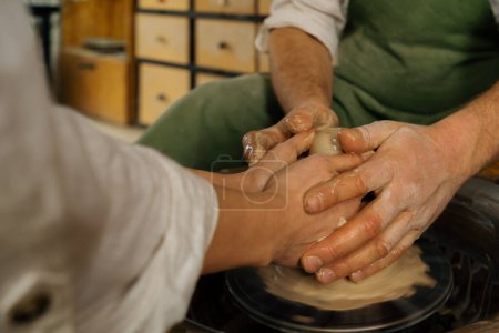 Téléchargez les photos : Potier atelier de poterie travaille avec le produit de roue de potier en potier d'argile conduit classe de maître - en image libre de droit