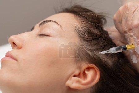 Photo for A beautician makes injections into the scalp for hair growth Mesotherapy for hair growth and strengthening in beauty salon A procedure against hair loss - Royalty Free Image
