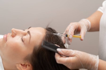 Téléchargez les photos : Un esthéticien fait des injections dans le cuir chevelu pour la croissance des cheveux Mésothérapie pour la croissance des cheveux et le renforcement dans le salon de beauté Une procédure contre la perte de cheveux - en image libre de droit