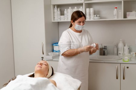 Téléchargez les photos : Procédure cosmétique pour rajeunir la peau du patient du visage dans une clinique de cosmétologie médecin fait procédure de beauté - en image libre de droit