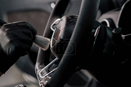 Foto de Worker limpia el volante cepillo profesional y la microfibra de peso Lavado y detalle profesional del coche Detallado interior - Imagen libre de derechos