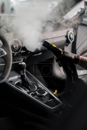 Photo for The concept of car cleaning and detailing The detailing master cleans the car interior with a hot steam cleaner Cleaning car interior - Royalty Free Image