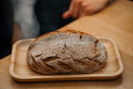 Téléchargez les photos : Gros plan, boulangerie - pain noir fraîchement cuit sur une surface tournante - en image libre de droit