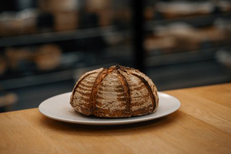Foto de Primer plano, panadería - pan oscuro recién horneado en la superficie giratoria - Imagen libre de derechos