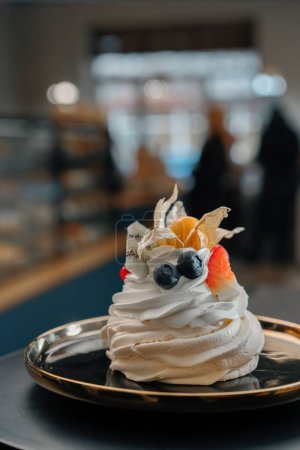 Foto de Primer plano panadería delicioso pastel de postre Pavlova en una superficie giratoria - Imagen libre de derechos