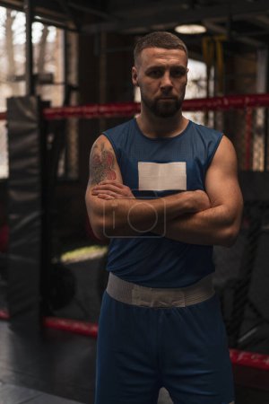Téléchargez les photos : Gros plan du boxeur sportif en sueur avec gymnase sérieux du visage avec bras croisés - en image libre de droit