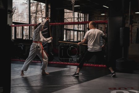 Téléchargez les photos : Deux combattants pratiquant avec épée en bois en Aïkido Sport et le concept des arts martiaux - en image libre de droit