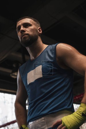 Téléchargez les photos : Gros plan boxeur masculin en sueur sportive avec un visage sérieux dans la salle de gym - en image libre de droit